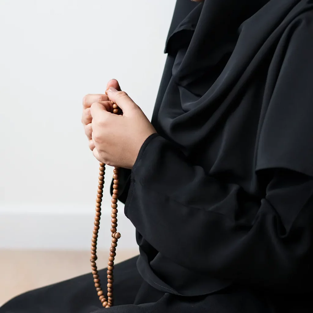 Woman in hijab holding prayer beads