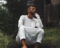 Man in a white thobe sitting on steps, deep in thought