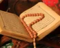 Open Quran with prayer beads resting on the page